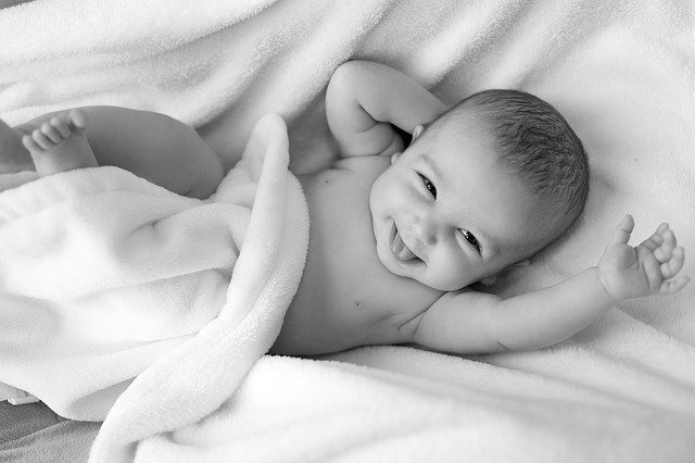 Nyfödd bebis som ler med hela ansiktet
